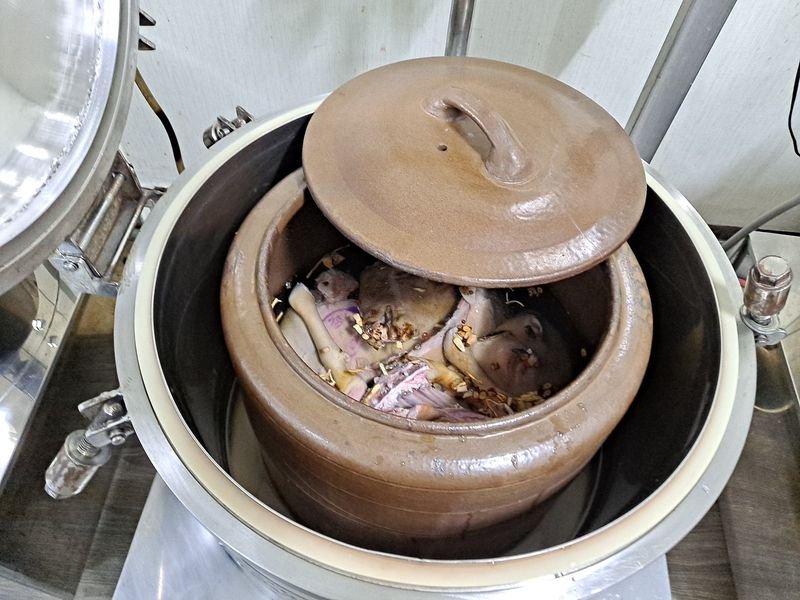 중탕기 안에 앉힌 옹기 항아리와 비스듬히 걸친 항아리 뚜껑, 안에 든 지육과 부재료